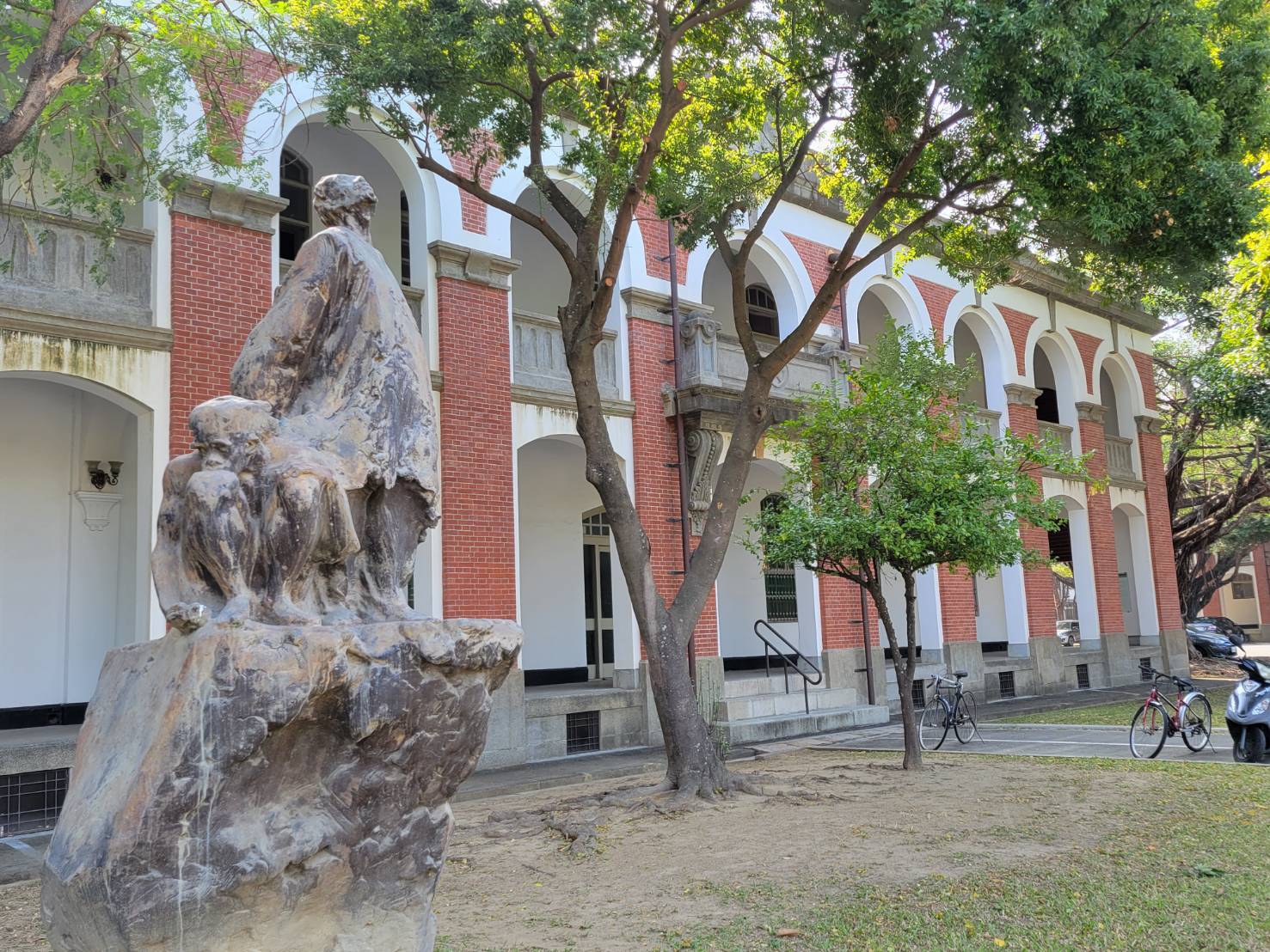 A stone sculpture in front of the red-brick arcades of the Former Liberal Arts Building, home of the Department of History